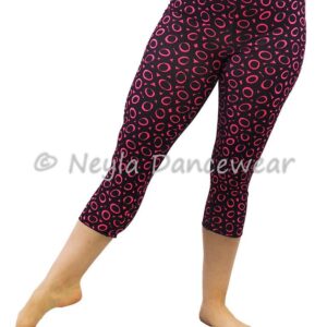 Femme portant les leggings courts Satiah avec imprimé cercles fuchsia sur fond noir pour la danse.